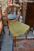 A pair of Victorian walnut balloon back dining chairs.