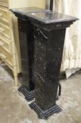 A pair of black marble pedestal columns.