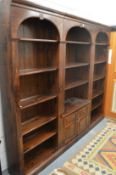 A stained pine three section floor standing cupboard bookcase.