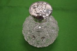 A cut glass and silver topped scent bottle.