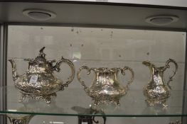 An early Victorian silver three piece tea service with embossed and chased decoration.