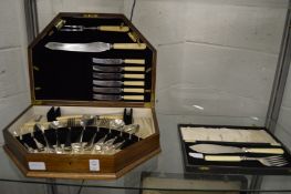 An oak cased part canteen of cutlery and a cased pair of fish servers.