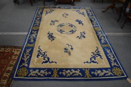 A Chinese carpet, cream ground within a blue border 270cm x 180cm.
