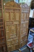 An Eastern carved and pierced hardwood two panelled dressing screen.