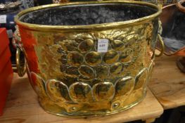 A good embossed brass coal or log bucket with lion mask handles.