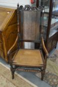 A 19th century walnut high back open armchair with cane work back and seat.