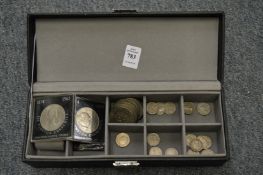 A watch box containing various coins.