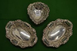 A silver heart shaped bon bon dish and a pair of similar oval dishes.