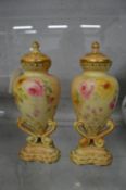 A pair of Worcester floral decorated blush ivory urn shaped vases and covers (small chips to