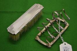 A silver toast rack and a hair brush.