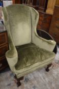 A George III design green draylon upholstered wing armchair.