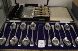 A cased set of twelve silver coffee spoons with matching sugar tongs and a cased set of silver