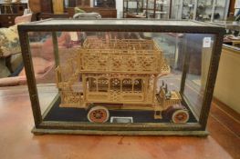 A wooden model of a Omnibus housed in a display case.