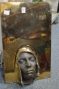 An unusual brass sculptural wall mask, signed.