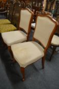 A pair of upholstered beech framed dining chairs.