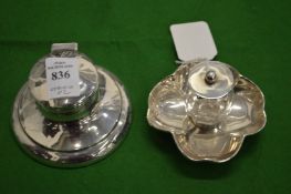 A small silver capstan inkwell and another inkwell.