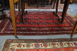 A modern Bokhara style carpet 185cm x 110cm.