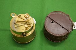 A brass surveying instrument with a leather case.