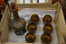 Filigree decorated amber glass decanter and six glasses.