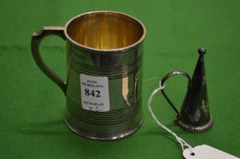 A small silver tankard and a silver candle snuffer.