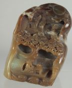 A CHINESE CARVED HARDSTONE GROUP, with buildings and a figure in a boat.