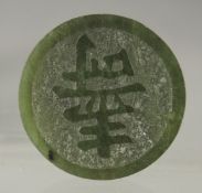 A SMALL CHINESE DARK JADE COIN, 3.5cm diameter.