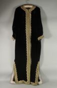 AN ARAB BLACK VELVET HOUSE COAT / ROBE, with gold thread decoration.