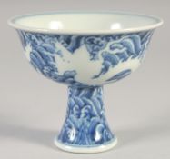 A CHINESE BLUE AND WHITE PORCELAIN STEM CUP, with white dragons and waves, bearing six-character