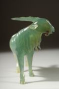A CARVED JADE FIGURE OF A GOAT on a wooden stand, 12cm long.