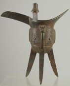A CHINESE ARCHAIC BRONZE RITUAL JUE CUP, on tripod legs, 20.5cm high.