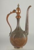 AN ISLAMIC ENGRAVED COPPER EWER, 35.5cm high.