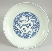 A CHINESE BLUE AND WHITE PORCELAIN DISH, with incised white dragon on stylised waves, six-