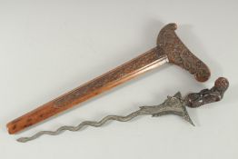 A FINE INDONESIAN JAVA CARVED WOOD AND DAMASCUS STEEL KRIS DAGGER, with carved figural handle and