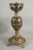 AN UNUSUAL MIXED METAL ENAMELLED BRASS LAMP, with central brass overlaid coconut, the circular
