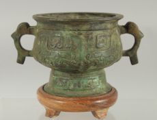 A CHINESE BRONZE TWIN HANDLE CENSER, with wooden stand.