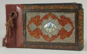 A FINE QAJAR SILVER MOUNTED LACQUERED WOOD BOUND ALBUM COVER, with small inset enamel plaque to