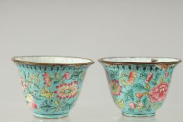 A PAIR OF CHINESE CANTON FAMILLE ROSE ENAMEL CUPS, 6cm diameter.