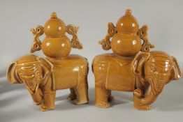 A PAIR OF CHINESE YELLOW GLAZE POTTERY ELEPHANTS, each approx. 22cm long.