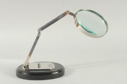 A CHROME MAGNIFYING GLASS on an oval base.