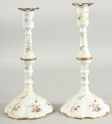 A PAIR OF 18TH CENTURY BILSTON ENAMEL CANDLESTICKS painted with flowers. 11ins high/