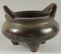 A GOOD LARGE CHINESE BRONZE CIRCULAR TWO HANDLED CENSER on three legs, Square mark. 10ins diameter.