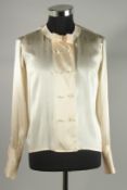 A CHANEL CREAM SILK BLOUSE with pearl style double C buttons and bow. Size 40