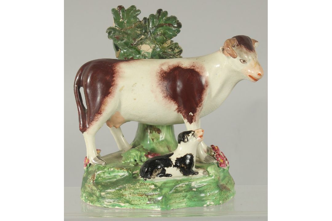 A STAFFORDSHIRE BOCAGE GROUP OF A COW AND CALF 5.5ins high. - Image 1 of 3