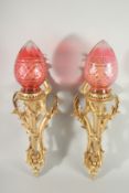 A GOOD PAIR OF LOUIS XVITH ORMOLU CORNET WALL LIGHTS with ruby shades. 24ins long.
