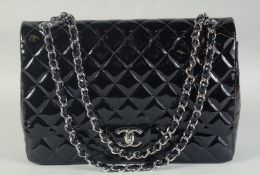 A VERY GOOD LARGE CHANEL BLACK PATENT LEATHER HAND BAG with long chrome and leather straps. 33cm