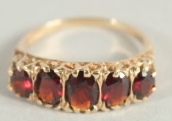 A VICTORIAN 9CT YELLOW GOLD FIVE STONE GARNET RING.