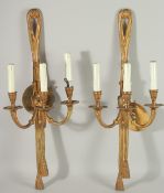 A PAIR OF GILT METAL THREE LIGHT WALL SCONCES. 25ins long.