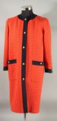 A CHANEL ORANGE DRESS COAT with navy trim and gilt Chanel double C buttons, silk lining. Size 38.