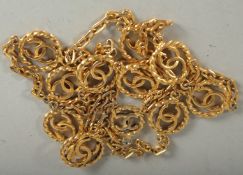 A GOOD CHANEL GILT LONG CHAIN with eleven double C's. 36ins long. Stamped, Chanel 1982.