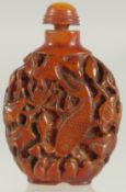 A CHINESE CARVED AMBER SNUFF BOTTLE AND SPOON.